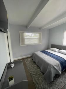 een witte slaapkamer met een bed en een raam bij Cheerful Family Home Close To Everything! in Tampa