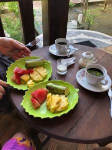 una mesa con dos platos de comida y tazas de café en Meno Turtle BUNGALOWS, en Gili Meno