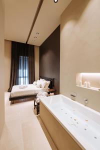 duża łazienka z wanną i łóżkiem w obiekcie Suite1212 - Bandiera w mieście Monopoli
