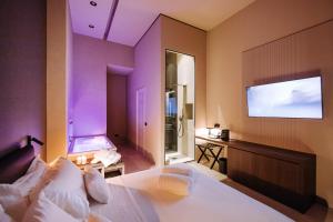 a bedroom with a bed and a flat screen tv at Suite1212 - Bandiera in Monopoli