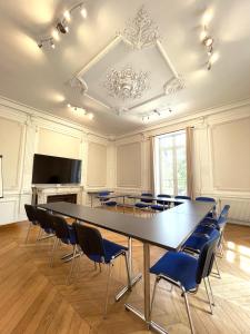 une salle de conférence avec une grande table et des chaises dans l'établissement Hôtel Valpré, à Écully