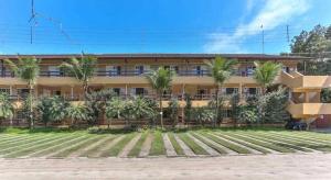 un bâtiment avec des palmiers devant dans l'établissement FLAT AMARILIS RIVIERA DE SÃO LOURENÇO, à Bertioga