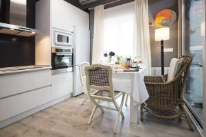 a kitchen with a white table and chairs in a kitchen at Mushara Apartamento Turístico in La Cumbre