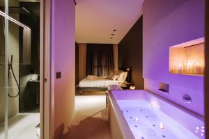 a purple bathroom with a tub and a bedroom at Suite1212 - Bandiera in Monopoli