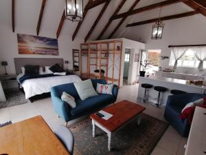 sala de estar con sofá azul y cama en Cape Dutch Flair, en Durbanville