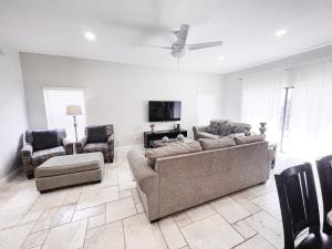 a living room with a couch and chairs and a tv at My Second Home Orlando in Orlando