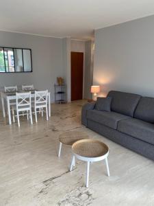 ein Wohnzimmer mit einem Sofa und einem Tisch in der Unterkunft Appartement La Pensée in Mandelieu-la-Napoule