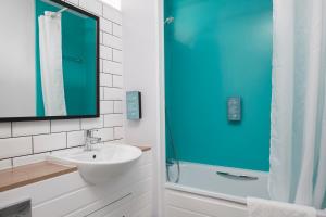 a bathroom with a sink and a shower at The Longshoot in Nuneaton