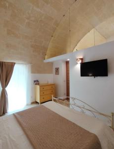 a bedroom with a bed and a flat screen tv at La Teresina Holiday Homes in Matera