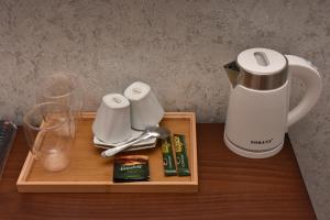 a tray with a coffee maker and glasses on a table at Hotel & Restaurant Sokhumi in Zugdidi