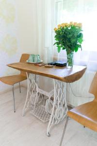 a wooden table with a vase of flowers on it at Cērpas in Medemciems