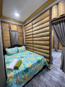 ein Schlafzimmer mit einem Bett und einer Holzwand in der Unterkunft HOMESTAY DUSUN ANA BALUN in Slim River