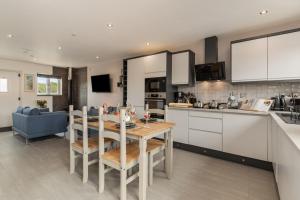 a kitchen and living room with a table and chairs at Sycamore Cottage in Tenby