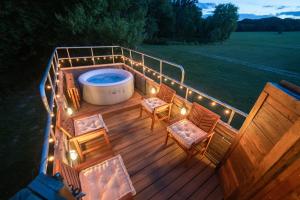 a deck with a hot tub and chairs and lights at Delightful 2 Bed Double Decker Bus with Hot Tub in Uckfield