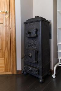una vieja estufa negra sentada junto a una puerta en Cērpas, en Medemciems