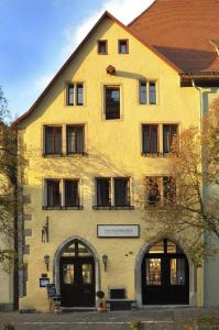 een geel gebouw met een bord aan de voorkant bij Hotel Herrnschloesschen in Rothenburg ob der Tauber