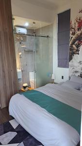 a bedroom with a large bed and a glass shower at Hotel My Cang in Trà Vinh