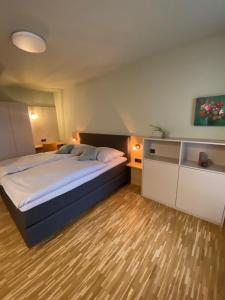 a bedroom with a large bed and a wooden floor at Con4rent Business Hotel plus in Kirchheim unter Teck