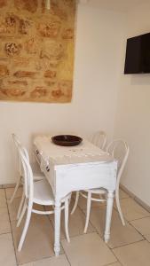 einen weißen Tisch und Stühle mit einer Platte darüber in der Unterkunft Dimora di charme Corte della Torre Salento in Morciano di Leuca