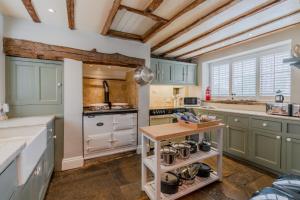 a kitchen with green cabinets and a table at The Hunting Lodge at Ragley Estate in Alcester
