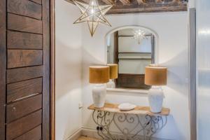 a mirror and two lamps on a table in a room at The Hunting Lodge at Ragley Estate in Alcester