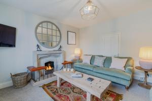 a living room with a couch and a fireplace at The Hunting Lodge at Ragley Estate in Alcester