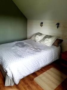 uma cama com lençóis brancos e almofadas num quarto em Gîte Le Passage 133 em Clavières-dʼOutre