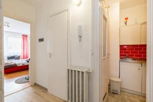 cocina con puerta blanca y pared roja en Aranykez 4-6: Downtown studio, en Budapest