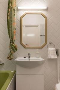 La salle de bains est pourvue d'un lavabo et d'un miroir. dans l'établissement Aranykez 4-6: Downtown studio, à Budapest