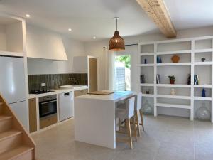 a kitchen with white cabinets and a table with chairs at Chez Georges - Maison 1 - Les Gîtes du Verdon in Esparron-de-Verdon +48 photos