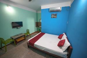 a bedroom with a bed and a blue wall at Selvasi Beach Cottage in Auroville