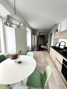 une cuisine avec une table blanche et des chaises vertes dans l'établissement Central Corner House, à Trieste