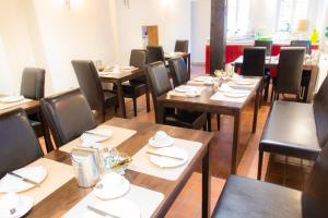 a dining room with wooden tables and chairs at Alte Windmühle - Hotel Garni in Hannoversch Münden