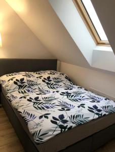 1 dormitorio con 1 cama con sábanas azules y blancas en Agroturystyka Liana, en Polanica-Zdrój