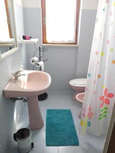 a bathroom with a sink and a toilet and a shower curtain at Casa nel Verde in Terni