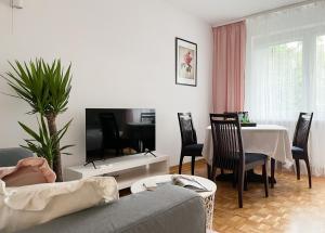 a living room with a couch and a table at Flower House Warsaw Chopin Airport in Warsaw