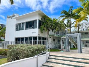 a white building with palm trees in front of it at Tranquilo in Fort Lauderdale