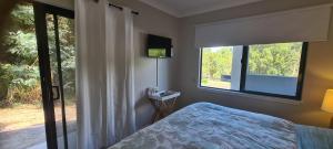 a bedroom with a bed and two windows and a television at Trinity Beach Escape in Trinity Beach