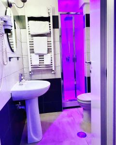 een roze badkamer met een wastafel en een toilet bij Bed Cinecittadue in Rome
