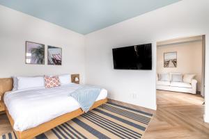 a bedroom with a bed and a flat screen tv at Hôtel le Rosay in Venise-en-Québec