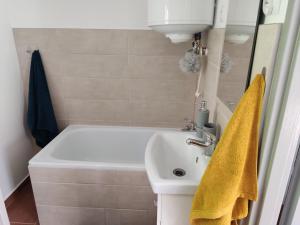 ein Badezimmer mit einem weißen Waschbecken und einem gelben Handtuch in der Unterkunft Domek z ogrodem in Mątki