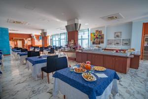 un restaurant avec des tables et des assiettes de nourriture dans l'établissement Best Western Hotel Nettuno, à Brindisi