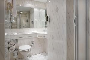 een witte badkamer met een toilet en een wastafel bij Hotel der Löwen in Staufen in Staufen im Breisgau