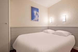 a bedroom with a white bed with two pillows at Résidence Pierre & Vacances La Daille in Val-d'Isère +45 photos