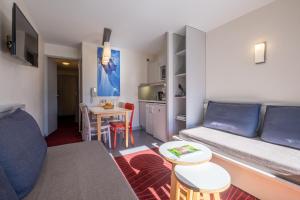 een woonkamer met een bank en een tafel bij Résidence Pierre & Vacances La Daille in Val dʼIsère