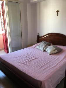 um quarto com uma cama com uma cruz na parede em Frank Sinatra - Appartamento vicino Taormina em SantʼAlessio Siculo