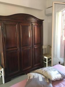 um grande armário de madeira num quarto com uma cama em Frank Sinatra - Appartamento vicino Taormina em SantʼAlessio Siculo