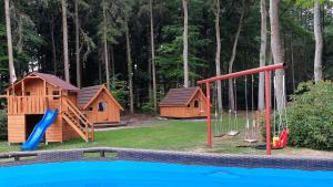 a playground with two houses and a slide at Gästehaus Bommelsen in Walsrode