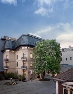 a hotel with a tree in front of a building at Hotel Bergs Suites in Rīga