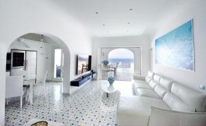 a living room with a white couch and a table at Villa sul mare - Praiano (Amalfi Coast) in Praiano